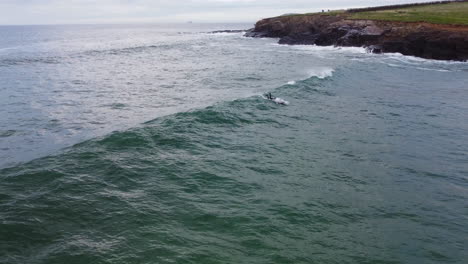 Surfer-enjoying-the-rough-seas-of-the-Cornwall-coast-at-Harlyn-Bay