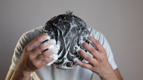 man-cleaning-his-hair-with-a-anti-dandruff-shampoo-foam,-using-hair-care-product