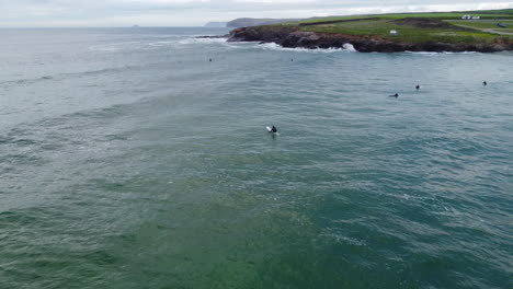 Surfers-enjoying-the-rough-seas-of-the-Cornwall-coast-at-Harlyn-Bay