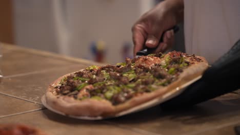 Fresh-pizza-from-the-oven-sizzling-and-covered-with-toppings-is-placed-on-the-countertop
