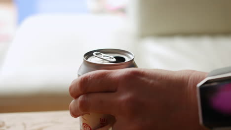 Woman-opening-a-can-of-soda-using-the-ring-pull-and-then-drinking