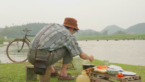 Close-up-of-man-cooking-food-outdoor-near-the-Lake
