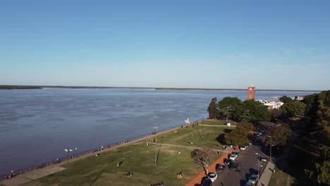 Beautiful-aerial-view-of-the-coast-of-Rosario-Argentina-at-the-afternoon-people-and-familys-enjoy-the-sun-along-the-coast-of-the-parana-river-with-a-beatyful-blue-sky-at-the-background