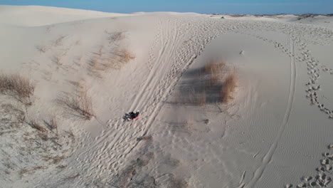 Sledding-on-Sand-Hills-and-Dunes-in-Desert-Landscape,-Aerial-View-of-Female-on-Board-Sledding-Downhill-in-Monahans-Sandhills-State-Park,-Texas-USA