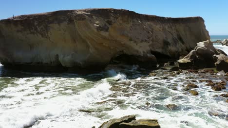 Waves-cause-erosion-to-form-an-arch-along-a-rocky-shoreline-in-Southern-California