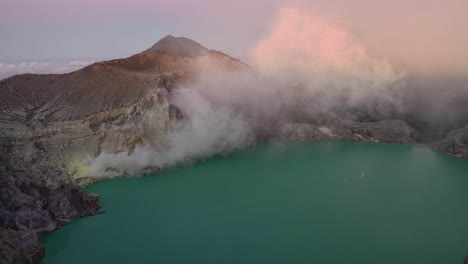 Dramatic-aerial-view-of-a-creator-at-Kawah-Ijen-volcano-with-turquoise-sulfur-lake-and-tourists