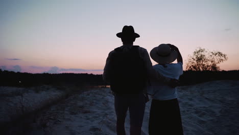 Couple-walking-on-sand-outdoors-during-blue-hour