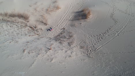 Sand-Sledding-on-Dune,-Aerial-View-of-Man-on-Board-Going-Down-on-Sandy-Hill-in-Monahans-Sandhills-State-Park,-Texas-USA,-Drone-Shot