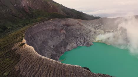 Aerial-view-of-a-creator-at-Kawah-Ijen-volcano-with-turquoise-sulfur-water-lake-at-sunrise