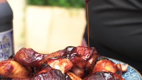 Dropping-barbecue-sauce,-in-slow-motion,-over-tasty-roast-chicken-wings