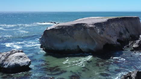 Erosion-along-a-rocky-ocean-shoreline-creates-rugged-cliffs-and-beautiful-vistas---sliding-aerial-view