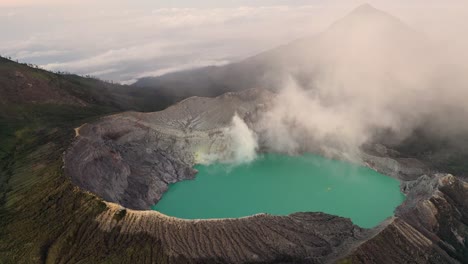 Aerial-view-of-a-rocky-creator-at-Kawah-Ijen-volcano-with-turquoise-sulfur-water-lake-at-sunrise