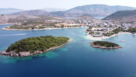 Cityscape,-Coastline-and-Small-Beach-at-Ksamil-Islands,-Albania---Reversing-Aerial