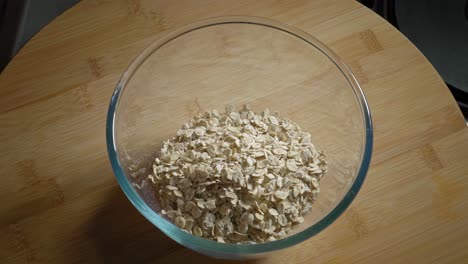 Pouring-Oat-Flakes-Into-A-Bowl-Then-Add-Cottage-Cheese,-Eggs,-And-Water