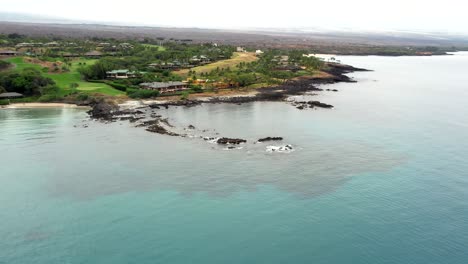 Stunning-blue-crescent-Kauna'oa-Bay-on-Kohala-western-Hawaii-coast-aerial-pull-back-shot