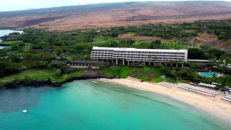 Aerial-Drone-View-Rising-Over-Oceanside-Manua-Kea-Beach-Hotel-Tourist-Destination-On-Big-Island-Of-Hawaii