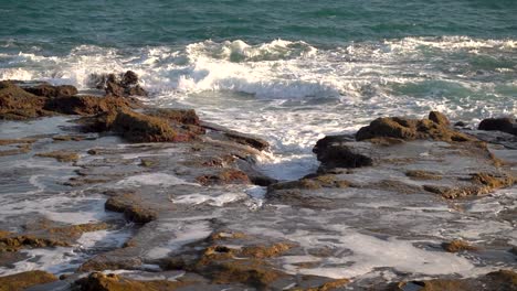 Slow-motion-scenery-of-waves-breaking-against-stony-reef-during-low-tide