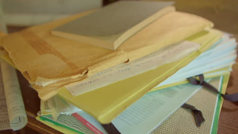 A-man's-hand-throws-folders-and-envelopes-of-papers-onto-a-pile-of-documents