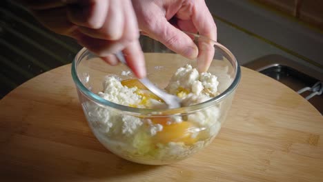Mixing-Oat-Flakes,-Eggs,-And-Cottage-Cheese-In-A-Glass-Bowl-Using-Fork