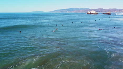 Surfistas-Surfeando-En-La-Costa-De-Ocean-Beach-Con-Rocas-De-Foca-En-La-Distancia-En-San-Francisco,-California