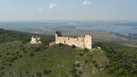 Děvičky-stone-castle-ruins-on-hill-overlooking-Mikulov,-drone-shot