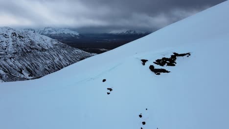 Luftaufnahme-Des-Schneebedeckten-Bergrückens,-Während-Sich-Die-Kamera-Zurückbewegt