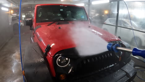 POV-power-washing-the-front-of-a-red-4WD-vehicle