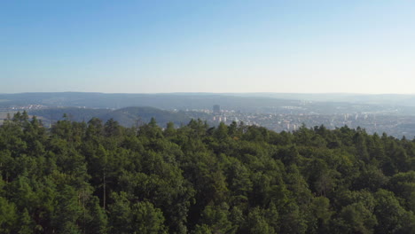 Beautiful-forest-covered-mountains-rise-above-the-picturesque-town-of-Brno,-Czech-Republic,-aerial-reveal