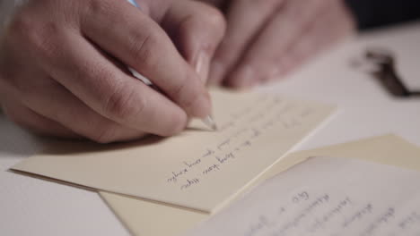 Close-up-a-hand,-writing-with-ball-pen-on-correspondence-paper