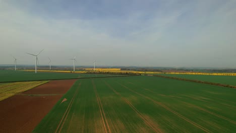 Wind-Turbines-On-Green-Agriculture-Field-In-Yorkshire,-UK---aerial-shot