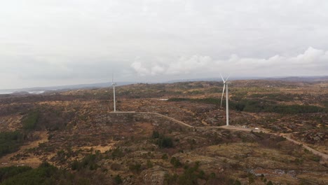 Lindesnes-windpark-in-Southern-Norway---Two-98-meter-tall-rotating-windturbines-producing-electricity-for-Asko-Fornybar-Norway---Aerial-overview-at-cloudy-day
