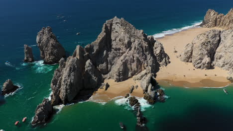 Cinematic-drone-shot-of-sea-cliffs-with-Playa-del-Amor-and-El-Arco-in-view-in-Cabo-San-Lucas-Mexico,-descending-slowly