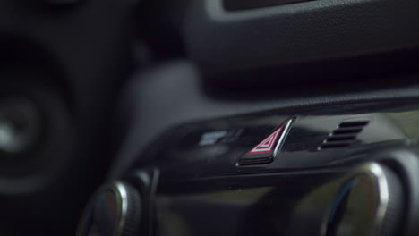 Close-up-of-person-finger-hitting-car-emergency-light-button-on-a-vehicle's-dashboard