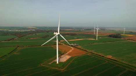Lissett-airfield-rotating-wind-turbine-farm-on-agricultural-farmland-aerial-static-view-Yorkshire-countryside