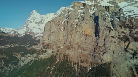 Aerial-slowly-rising-up-massive-cliff-face-in-Swiss-Alps-near-Lauterbrunnen