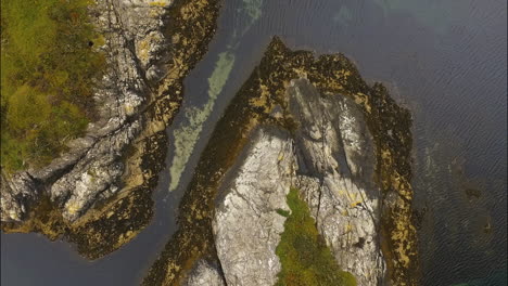 Large-Cliffs-in-Water,-Covered-with-Grass,-Aerial-Top-Down-Drone-View