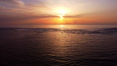 Fliegen-über-Den-Ruhigen-Ozean-Mit-Dramatischem-Sonnenuntergang-Im-Hintergrund
