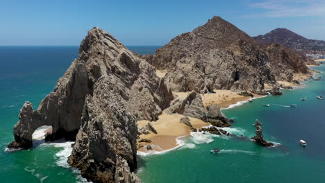 Drone-shot-of-El-Arco-and-Playa-del-Amor-with-boats-in-the-ocean-in-Cabo-San-Lucas-Mexico
