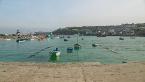 Angelegte-Boote-Im-Ruhigen-Türkisfarbenen-Meerwasser-Am-Hafen-Von-St.-Ives-Tagsüber-In-Cornwall,-Südwesten,-Großbritannien