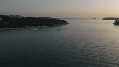 Aerial-5K-Drone-Over-Calm-Ocean-With-Boat-In-Croatia-Harbor-Inlet-At-Sunset