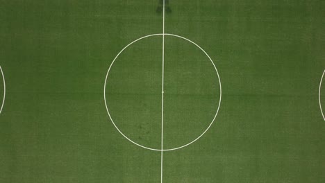 Drone-shot-of-a-football-field-with-birds-eye-view---drone-is-ascending-from-the-kick-off,-revealing-the-whole-pitch