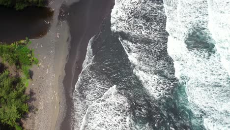 Waves-wash-ashore-Black-Sands-Beach-at-Punalu'u-on-Hawaii's-Big-Island---straight-down-aerial-bird's-eye-view