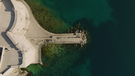 Aerial-5K-Drone-Birdseye-View-Over-Paved-European-Oceanfront-Walkway-In-Croatia