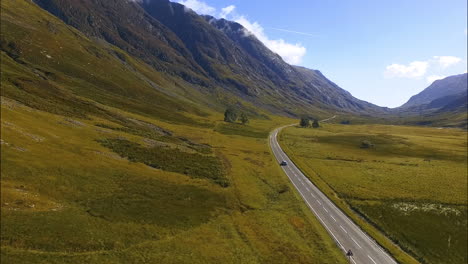 Car-Travels-on-Paved-Mountainside-Road-in-Scotland,-Aerial-Tracking