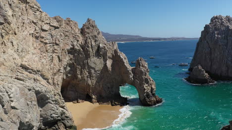 Aerial-shot-of-El-Arco-and-Playa-del-Amor-slowly-revealing-boats-in-the-ocean-in-Cabo-San-Lucas-Mexico