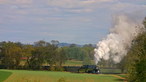 Blick-Auf-Einen-Antiken-Dampfpersonenzug,-Der-An-Einem-Herbsttag-Durch-Bäume-Und-Ackerland-Fährt