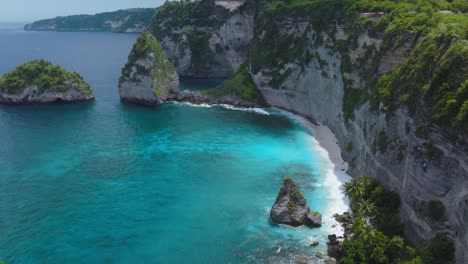 Flying-past-Jogglo-Viewpoint-revealing-turquoise-water-at-Diamond-Beach,-Nusa-Penida,-aerial