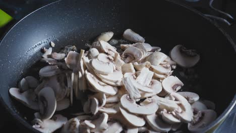 Adding-Sliced-Mushrooms-Into-Hot-Pan-Greased-With-Butter