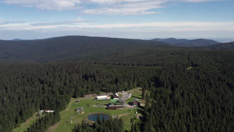 Slowly-orbiting-the-beautiful-forest-surrounding-the-mountain-hotel,-Paprsek,-aerial-panorama