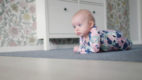 Beautiful-baby-learning-to-crawl-on-home-floor,-cinematic-low-angle-view